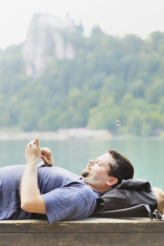 游客在湖边使用智能手机