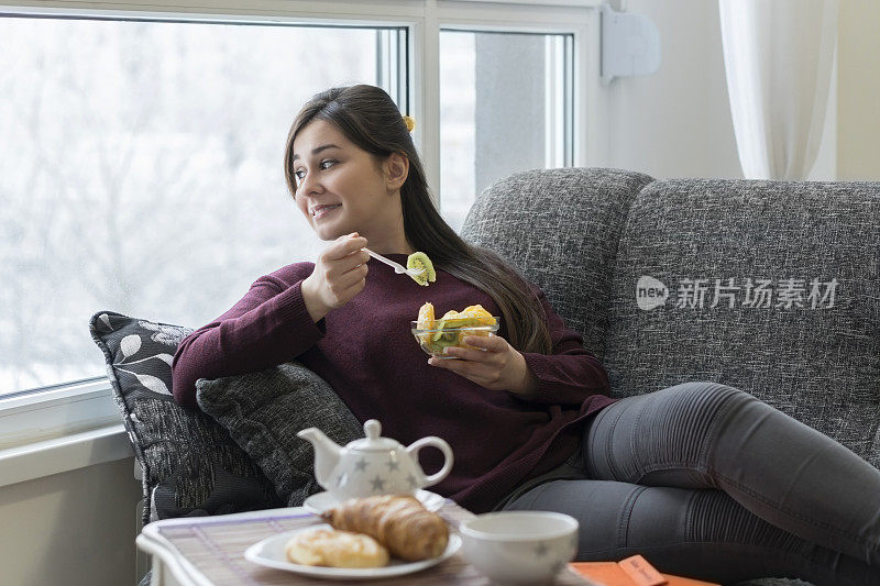 年轻女子正在家里吃早餐