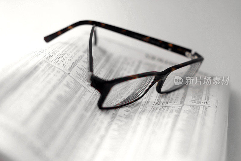 在折叠的报纸上的斑点眼镜-股票报价