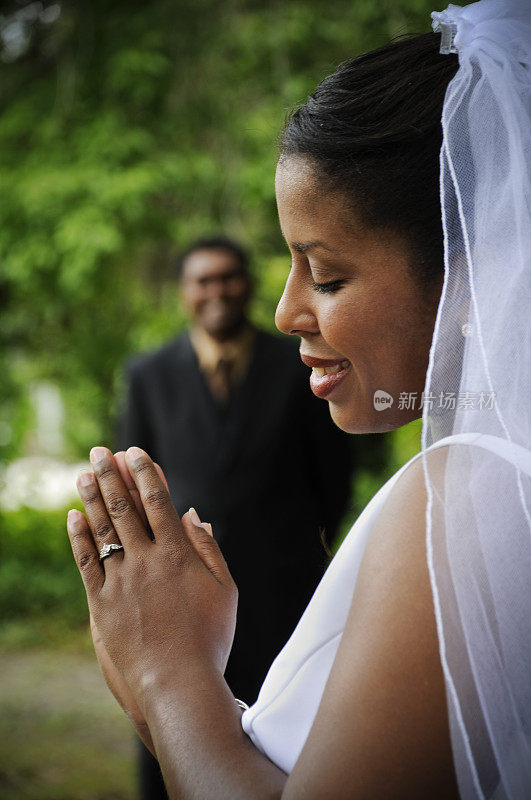 新娘看着她的结婚戒指，新郎看着。