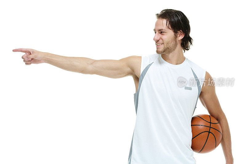 微笑的运动员拿着篮球指着