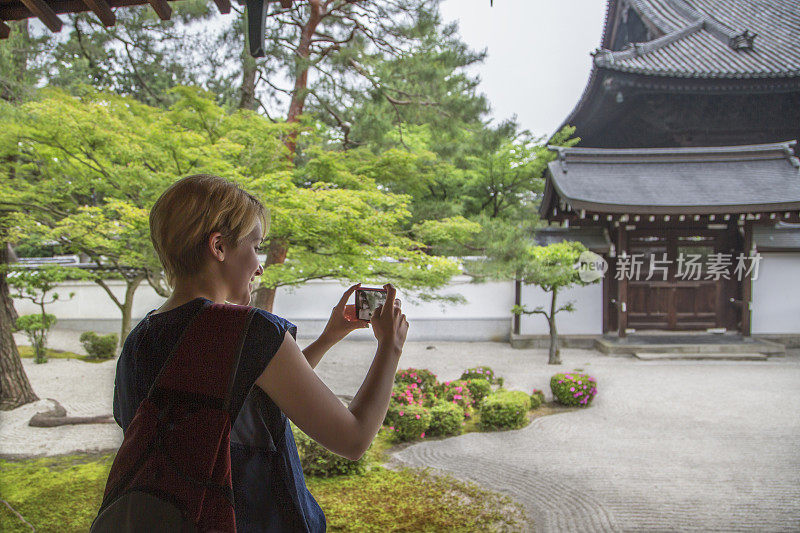 游客在日本寺庙花园内拍照