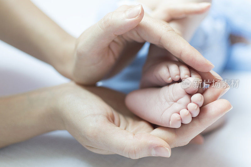 新生婴儿的脚在母亲的手中