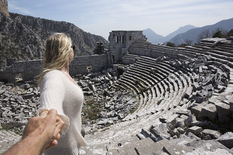 女人牵着男人的手看古希腊废墟
