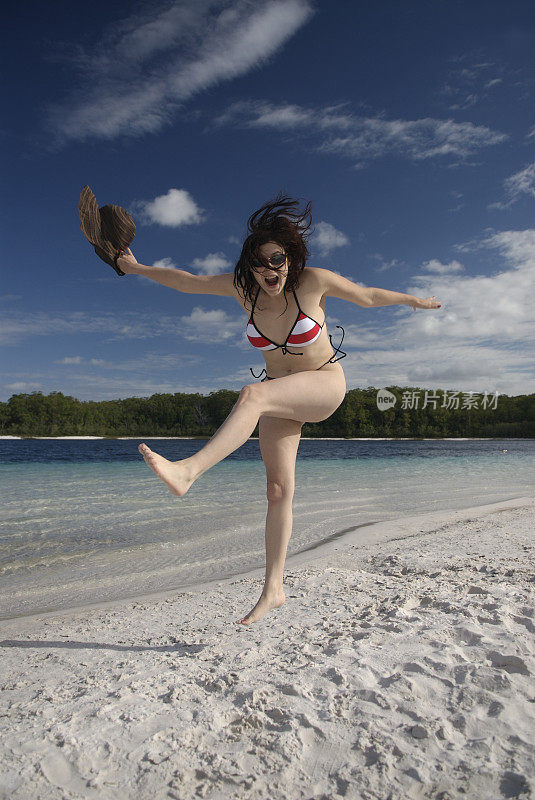 快乐女孩在海滩上跳