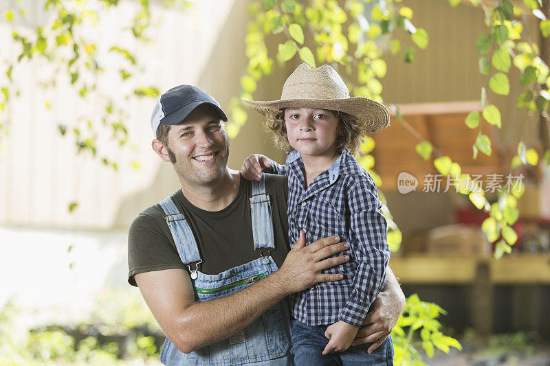 父亲和儿子在家庭农场对着镜头微笑