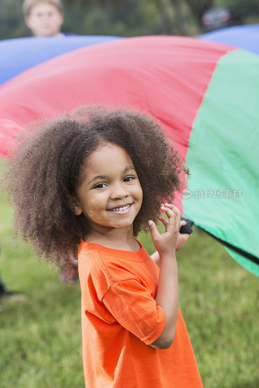 非裔美国女孩在夏令营拿着降落伞