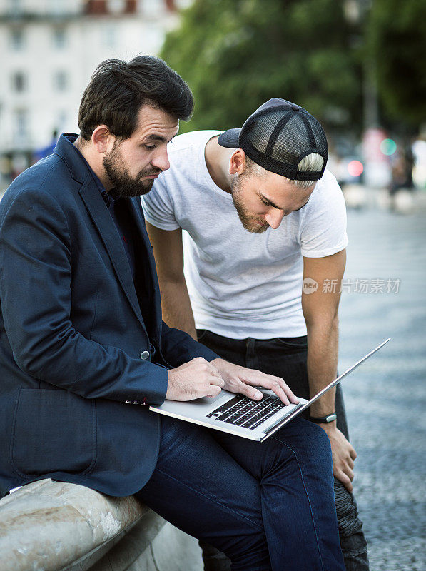 商人和开发人员在街上用笔记本电脑工作