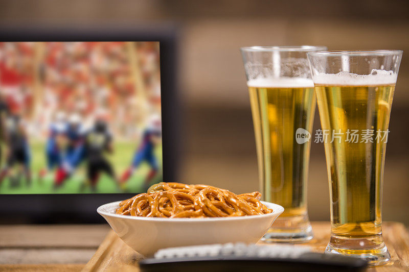 在酒吧或家里看电视足球赛。啤酒。