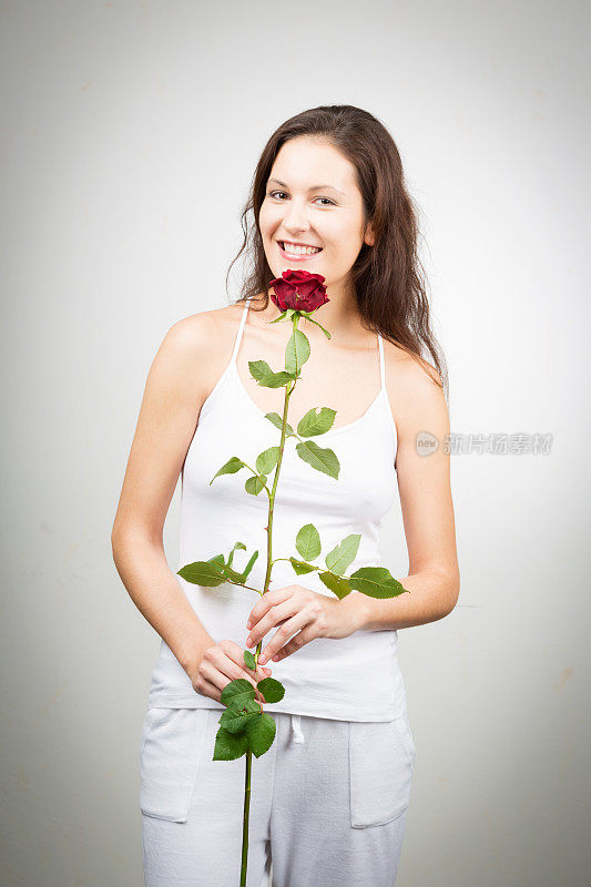 手持一朵玫瑰的女子