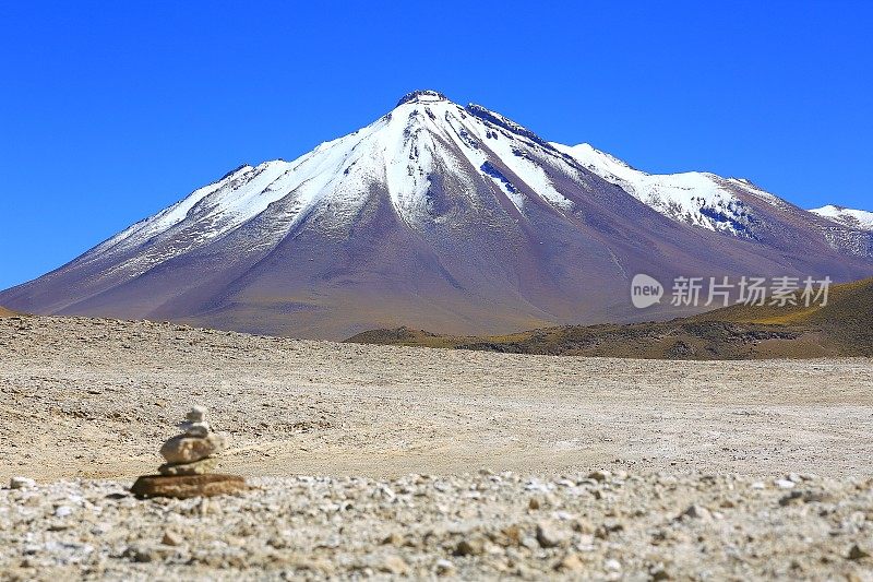 Inukshuk岩石形成和戏剧性的景观:积雪覆盖的火山和田园般的阿塔卡马沙漠草原，火山景观全景-圣佩德罗阿塔卡马，智利，Bolívia和阿根廷边境