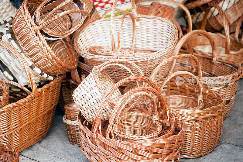 一堆柳条篮子陈列在市场的摊位上。