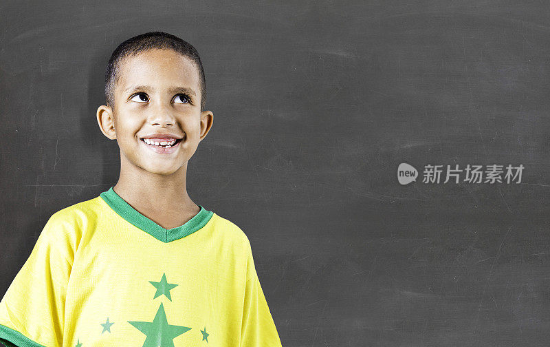 满面笑容的孩子在黑板前。学校的概念