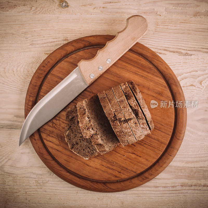 黑麦面包片和刀放在厨房板上