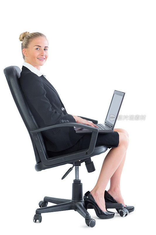侧面的可爱的金发女商人坐在办公室的椅子上