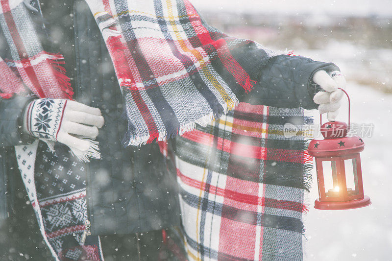 年轻女子在雪地里提着灯笼