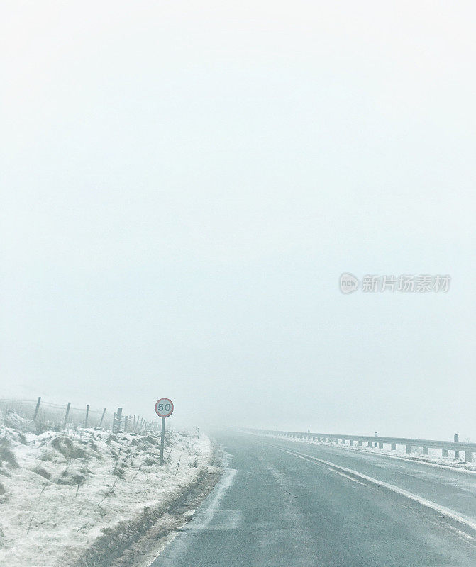 白色的风景-雾蒙蒙的单车道在一个下雪的日子，在萨德尔沃思沼泽，峰区国家公园，英格兰