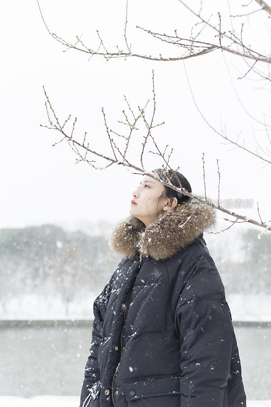 一个美丽的亚洲女人站在雪地里的肖像