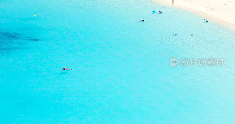 人们在加勒比海清澈的热带水域中漂浮的鸟瞰图