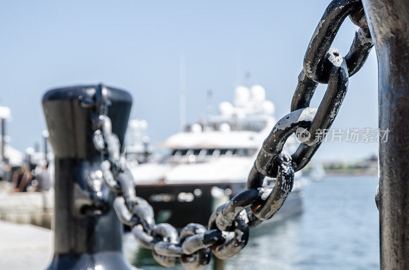 在夏天的一天，在波士顿码头的锚链与游艇后面