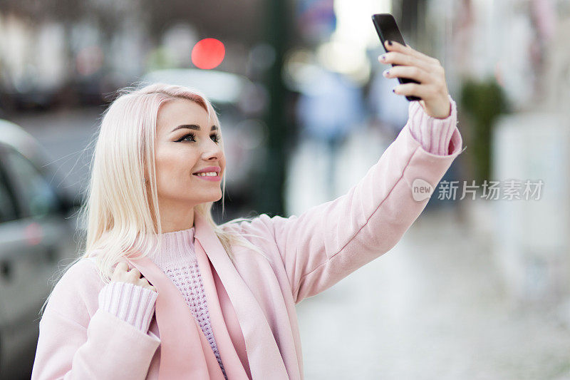 现实生活中的时尚年轻女子，她在自拍