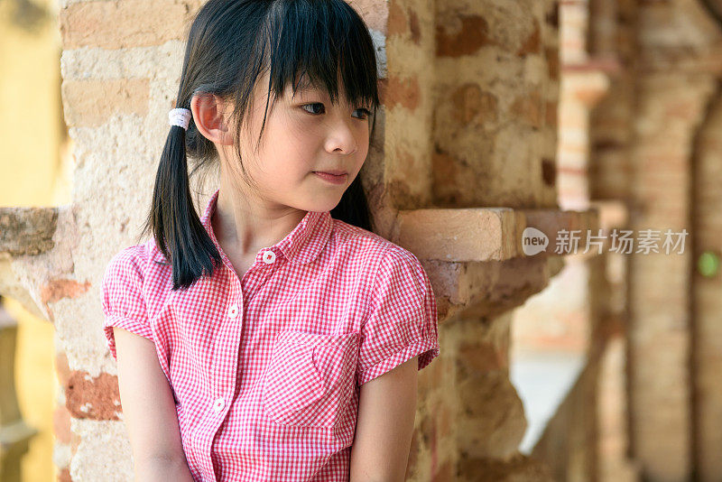 穿着粉红色衬衫的年轻亚洲女孩在想什么