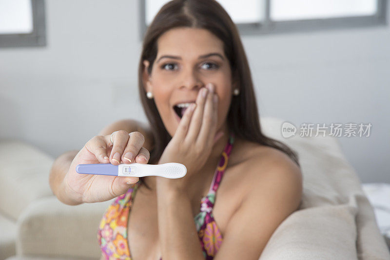 快乐的年轻女子，怀孕测试呈阳性