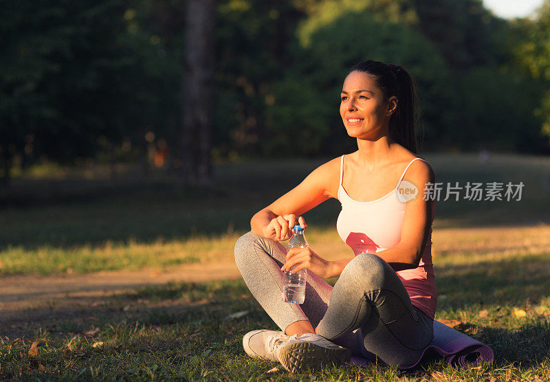 妇女在户外健身运动训练后喝水