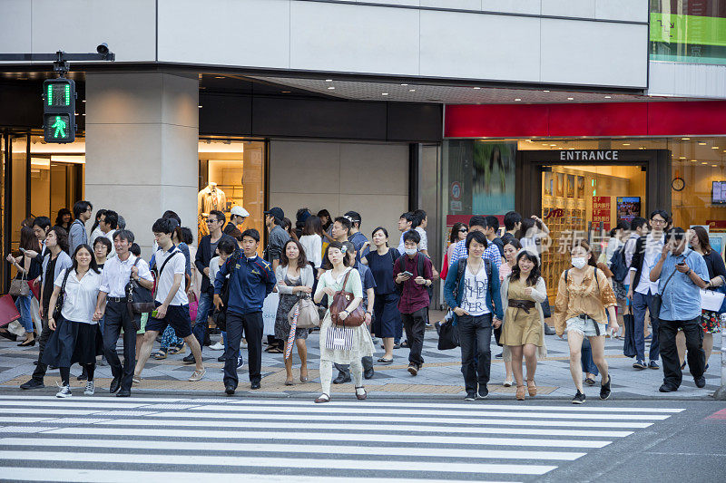 在日本东京，一大群人穿过马路