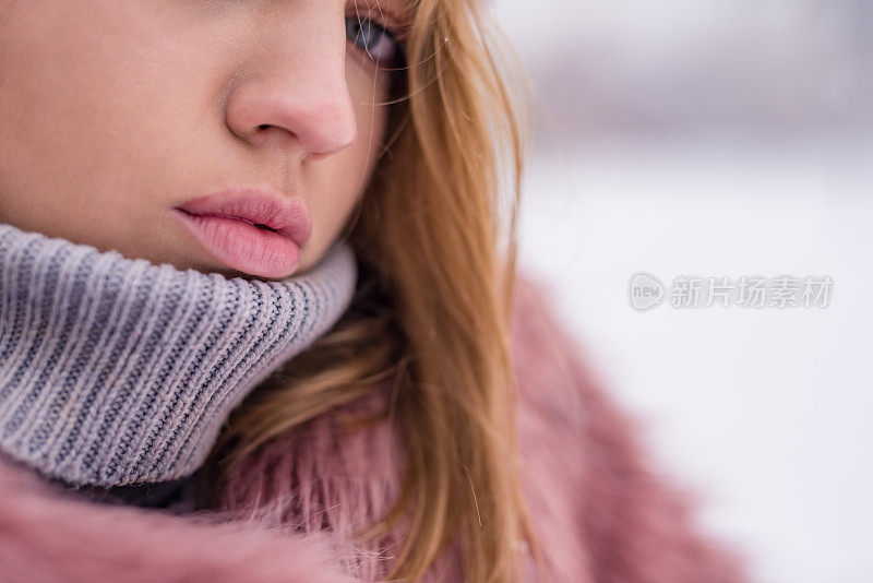 美丽的蓝眼睛少女在寒冷的雪天嘴唇闭合。