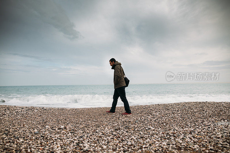 下雨天在海滩上散步的人