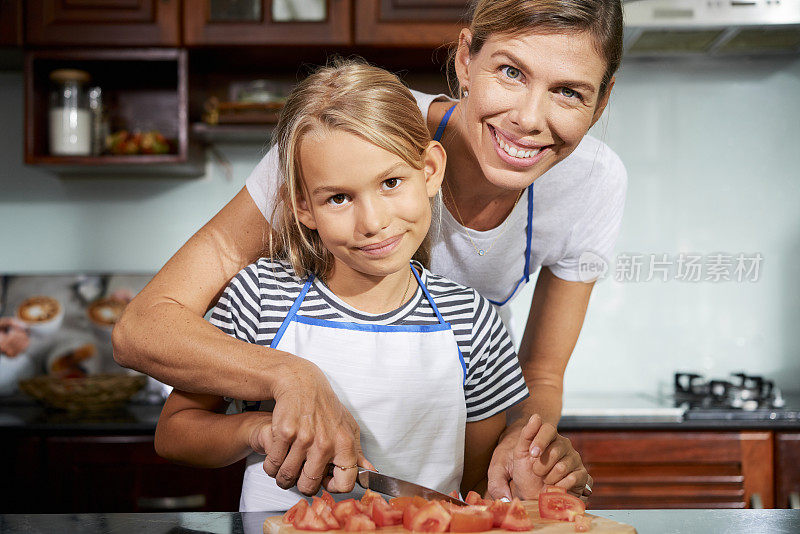 母亲在教女儿如何做饭