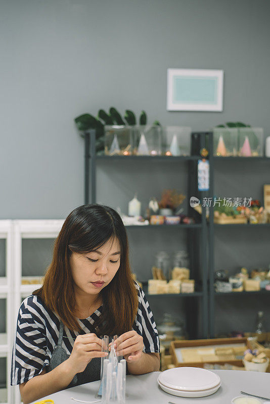 一名亚裔华人女性用铝线取出蜡烛芯