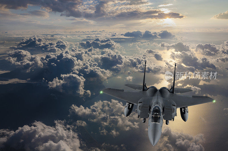 战斗机在日落时飞过云层