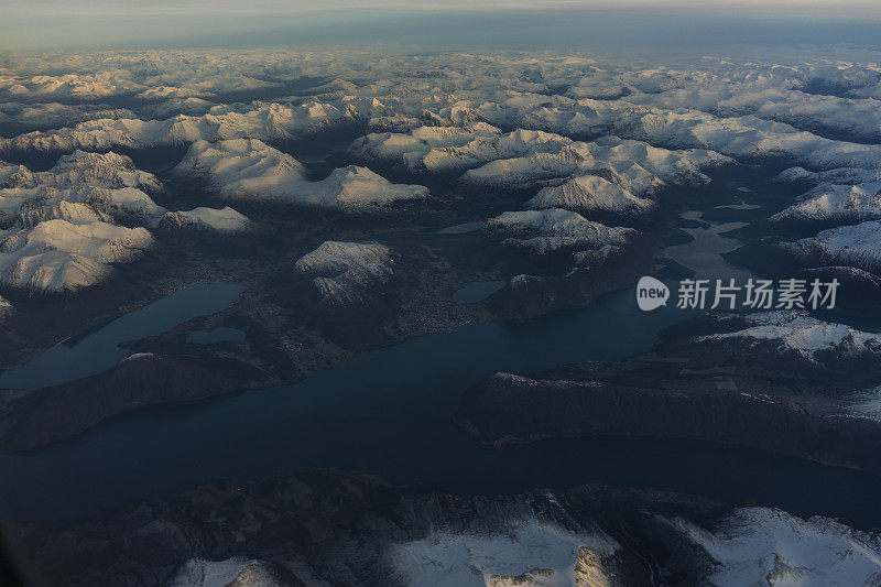 乘客从飞机上俯瞰挪威的峡湾，山上覆盖着积雪