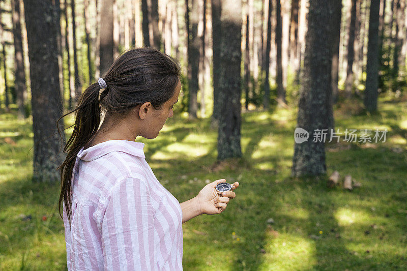 回归自然。独自寻找道路的旅行者。一个快乐的年轻女游客漫步在大自然中。阳光明媚的日子里在森林里的户外享受。