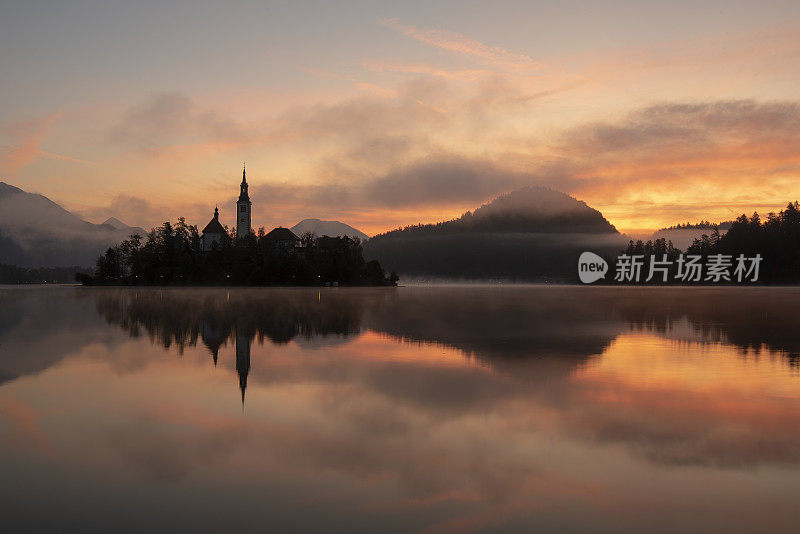 日出时流血的湖-流血的岛屿与太阳的背景和雾蒙蒙的，浪漫的气氛-斯洛文尼亚