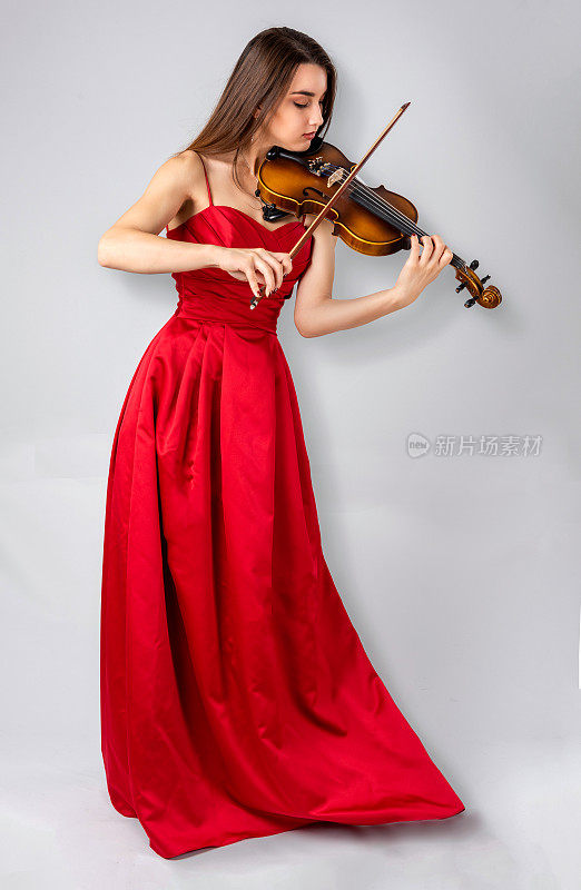 年轻的女小提琴手站着拉小提琴