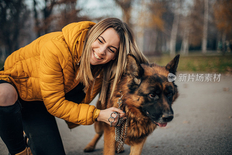 年轻女子和德国牧羊犬在公园里玩