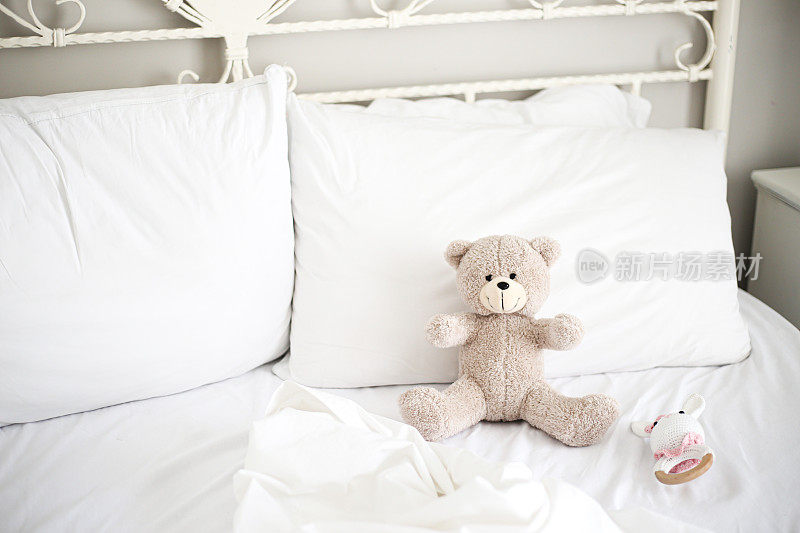 新生儿的快乐和卧室里的泰迪熊