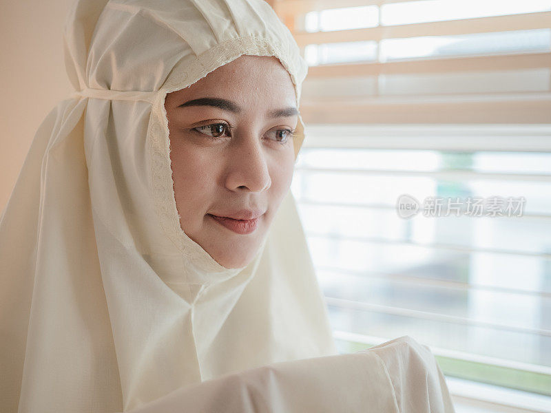 年轻的穆斯林妇女在家里祈祷