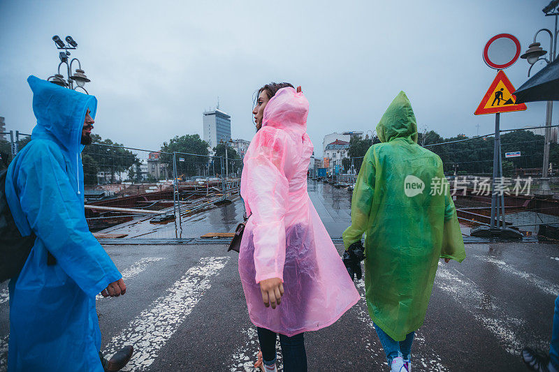 一群人穿着雨衣穿过人行横道。