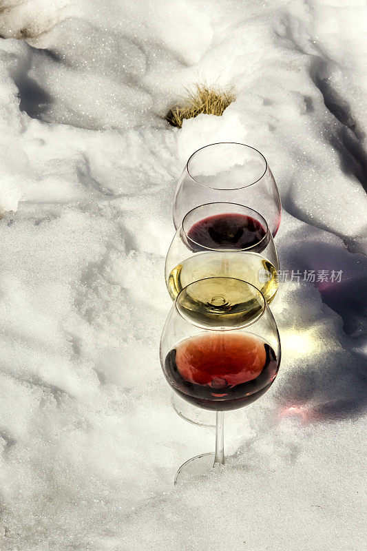 红色，rosé和白葡萄酒在新鲜的雪上。
