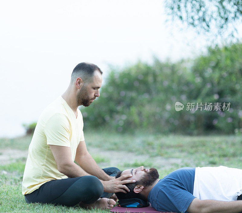 一个男人在给她的病人做瑜伽治疗