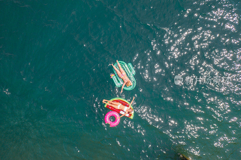 鸟瞰图的妇女漂浮在湖上与充气筏