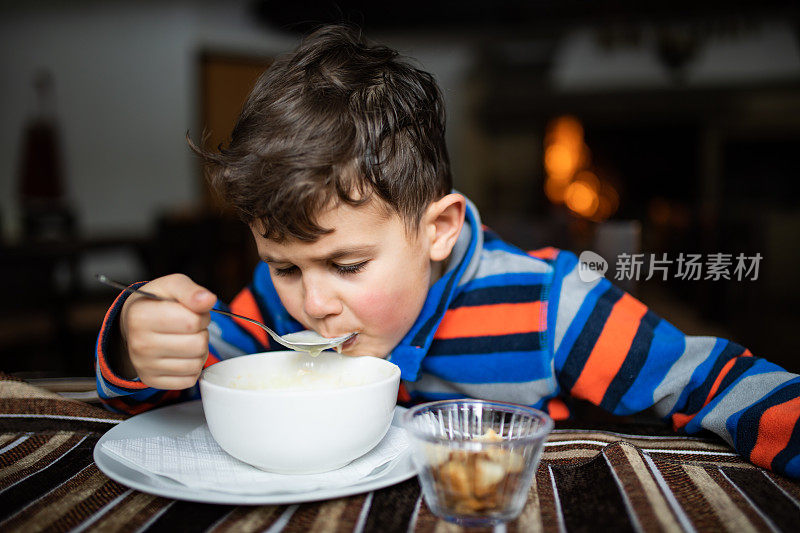 一个喝汤的可爱男孩