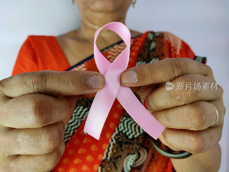 印度妇女手拿粉红丝带，乳腺癌意识象征，与癌症抗争