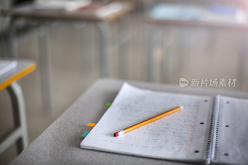笔记本和铅笔在空教室的书桌上