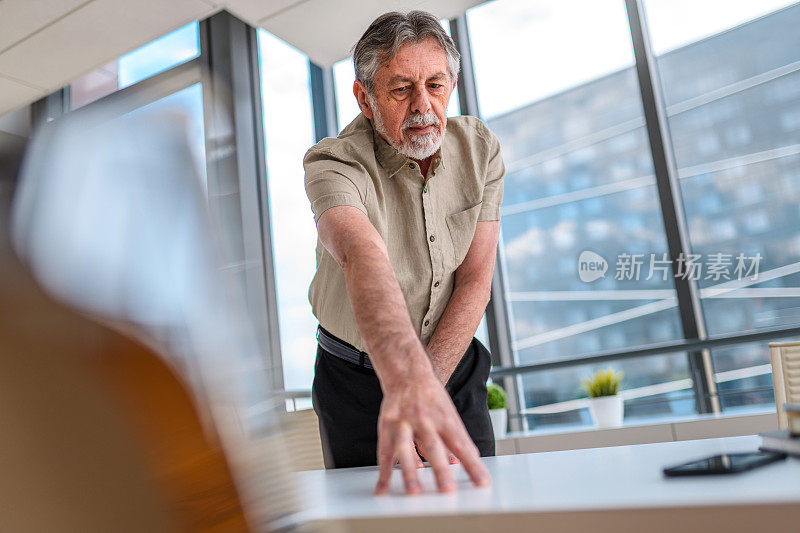 成熟的商人在现代办公中触摸虚拟触摸屏和使用数字界面