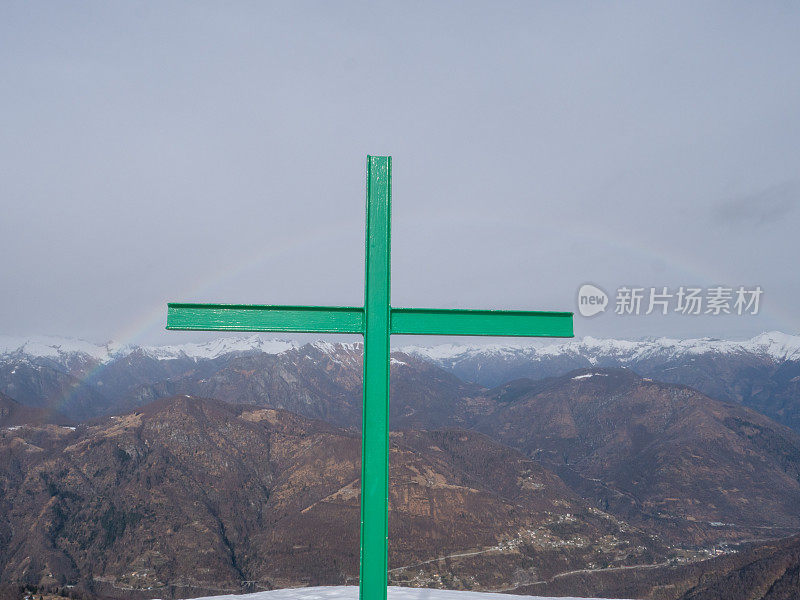 彩虹在瑞士阿尔卑斯山的提契诺，宗教十字架在山顶